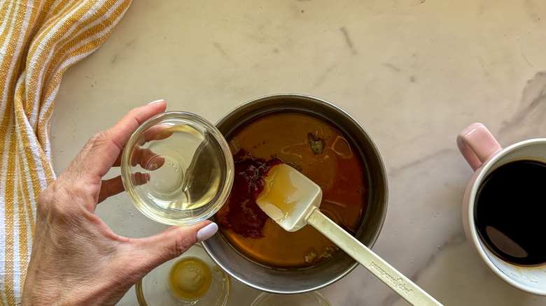 adding sauce ingredients to pot