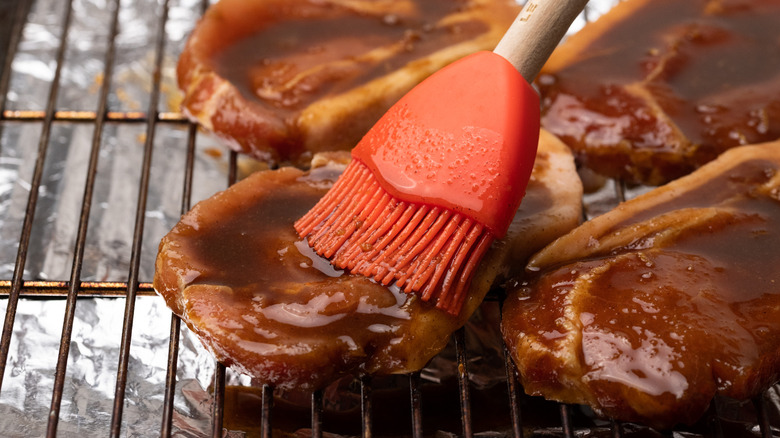 Brushing pork steak with marinade