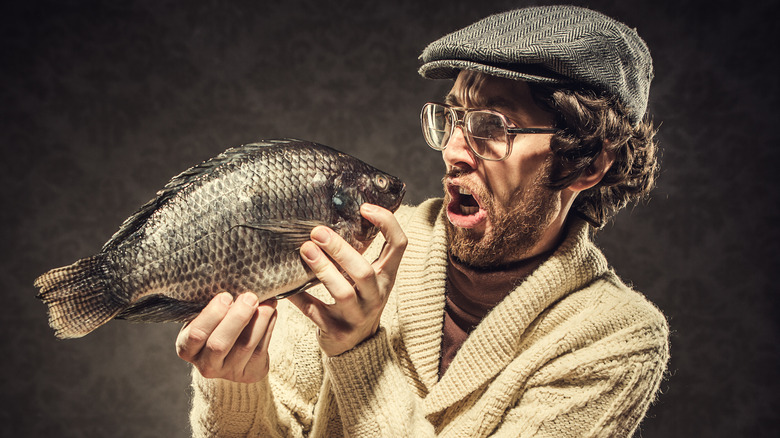 man eats whole fish raw