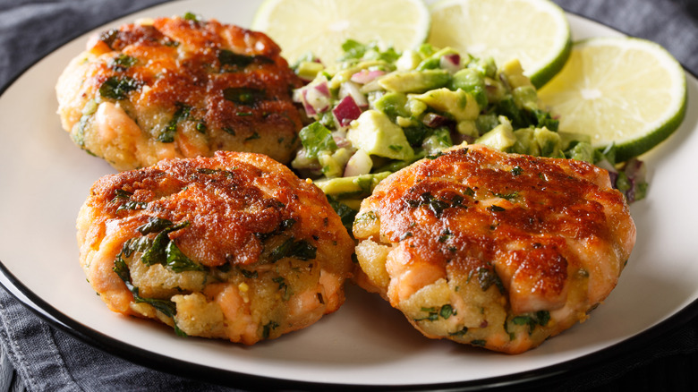 salmon burger patties served with avocado and lime