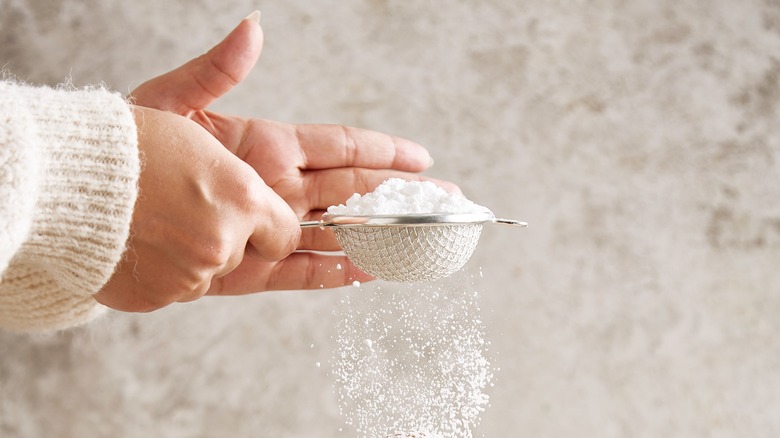 Hands sifting powdered sugar 