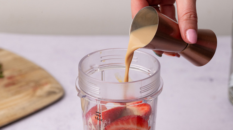 Pouring baileys into a blender