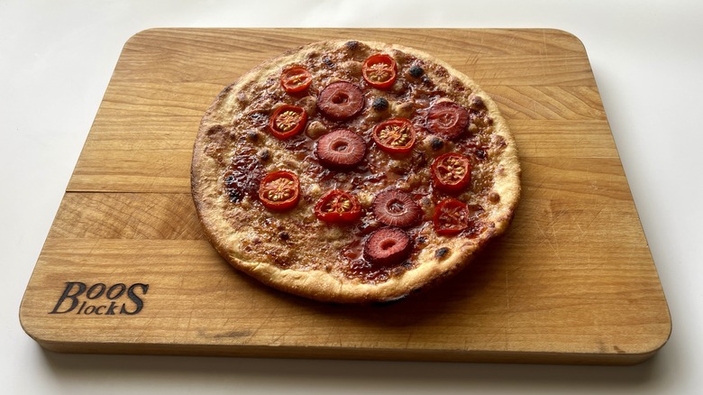 broiled pizza on cutting board