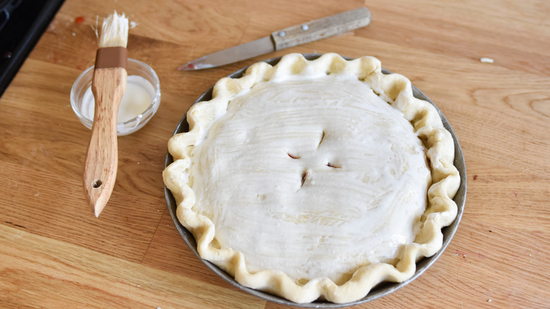 brushing cream on pie dough