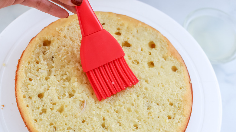 Cake being brushed with lychee syrup