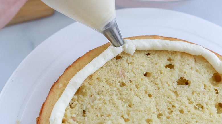 Icing being piped on a cake