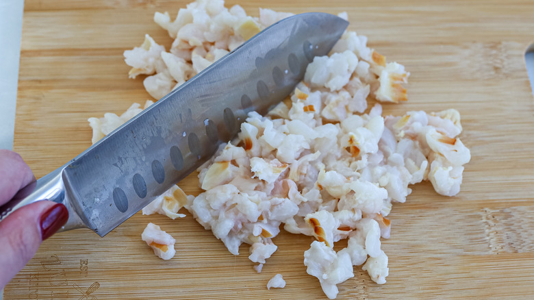 Lychees being chopped on a cutting board