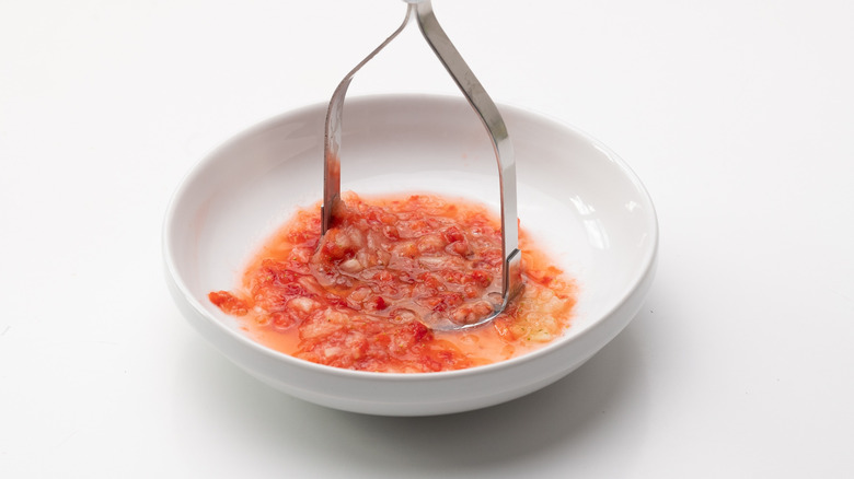 Mashing strawberries in a bowl 