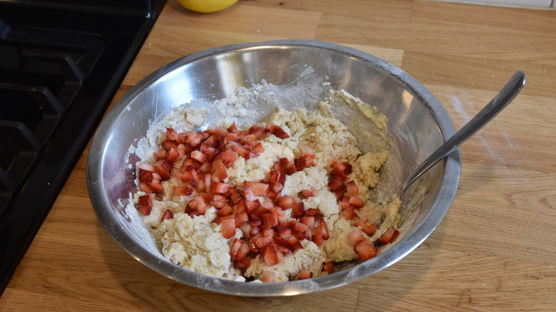 stirring strawberries into dough