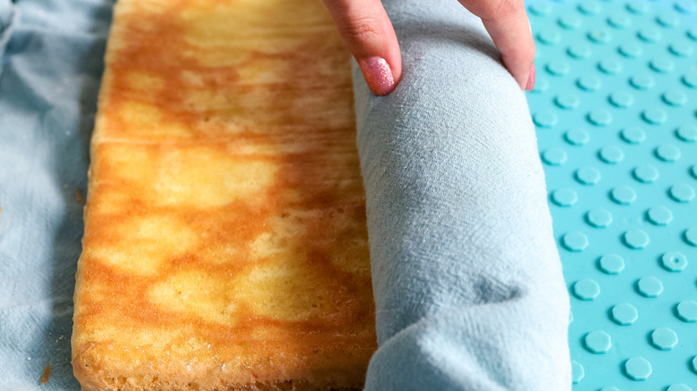 hand rolling cake in towel