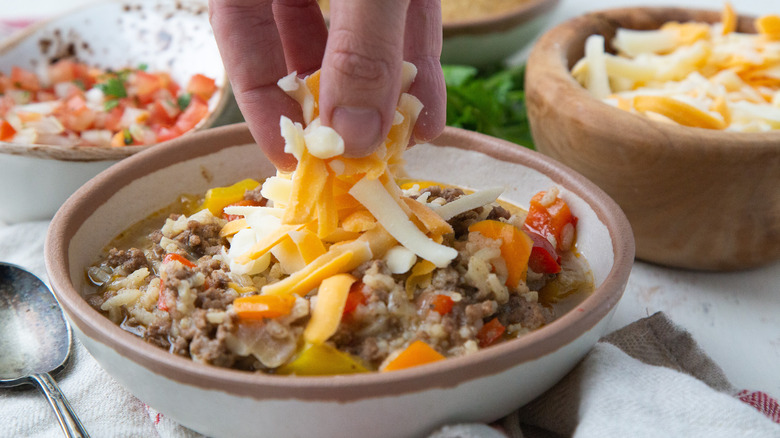 sprinkling cheese onto soup bowl