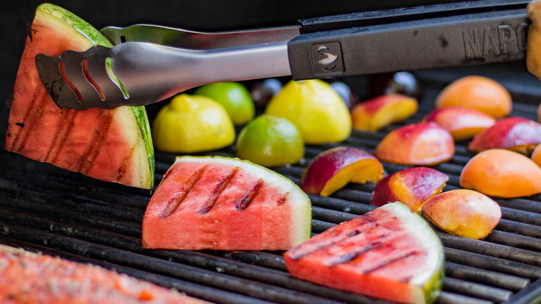 tongs holding grilled watermelon