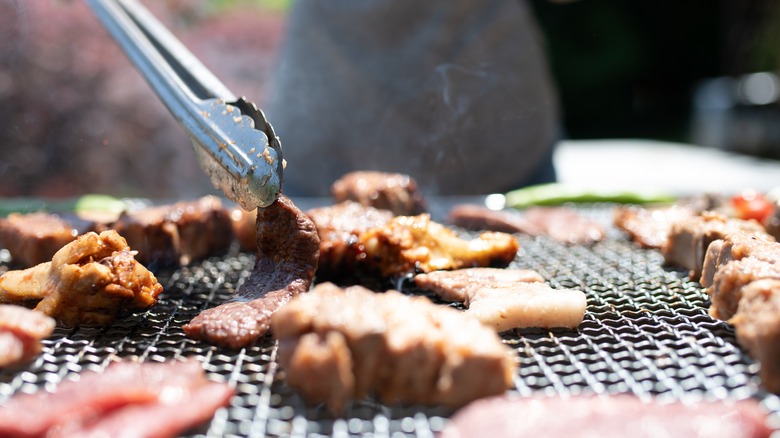 tongs grabbing meat