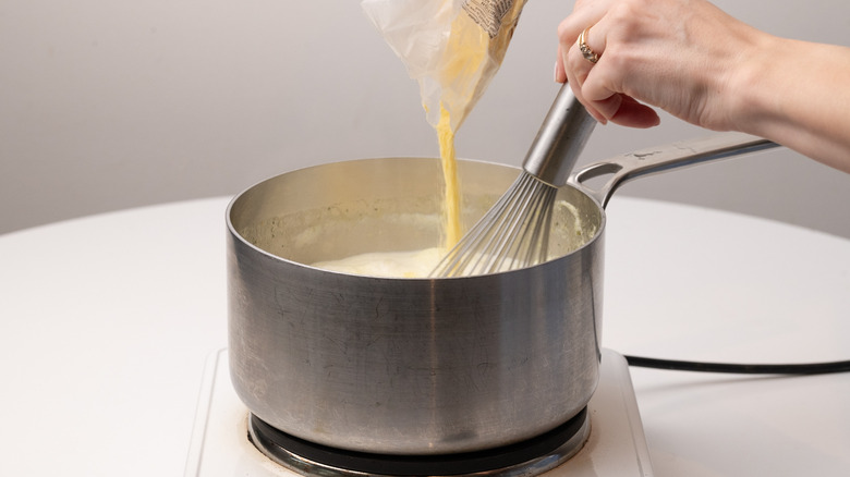 whisking polenta into milky stock