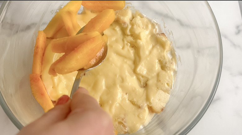 peaches being spooned over pastry cream