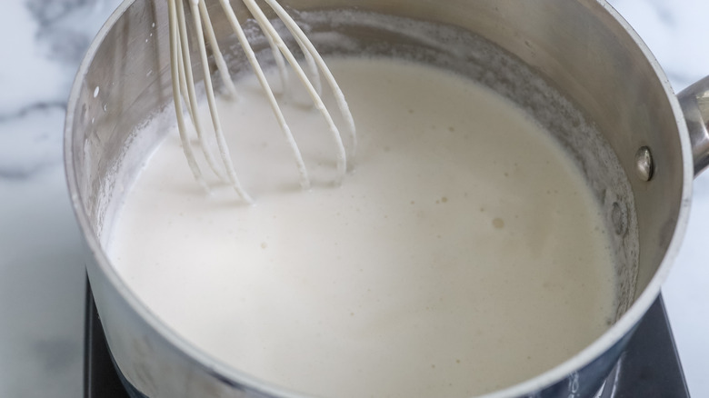 cream in a saucepan with a whisk