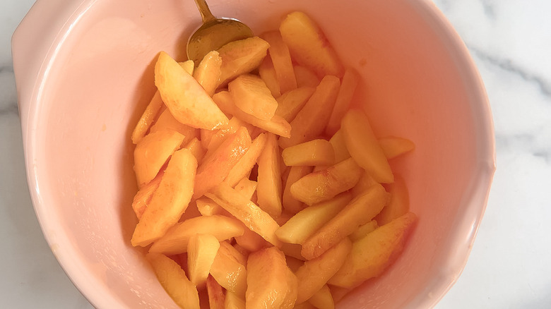 sliced peaches and lemon juice in a bowl