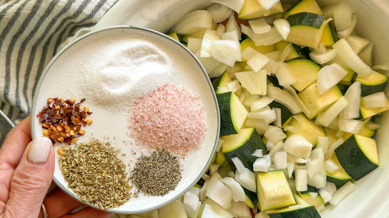 hand adding spices to cooker