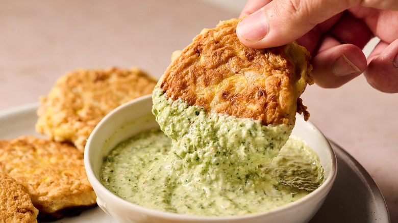 dipping fritter in pesto goat cheese