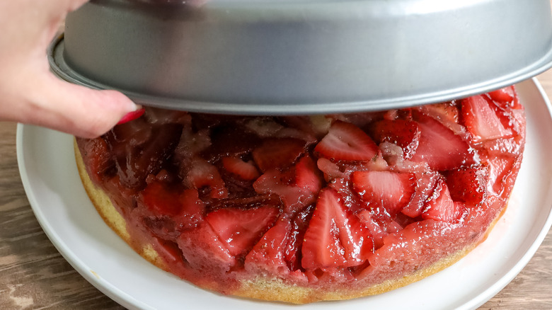 strawberry basil upside down cake being inverted onto a plate