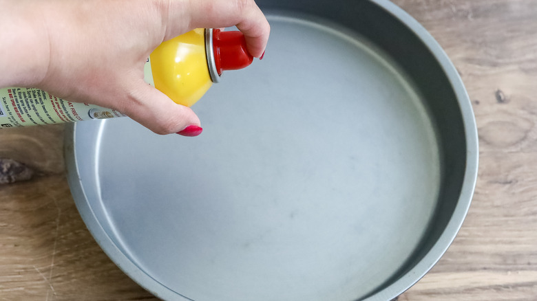 round pan being sprayed with cooking spray