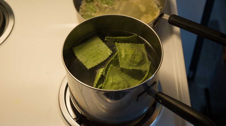 green ravioli boiling in pot