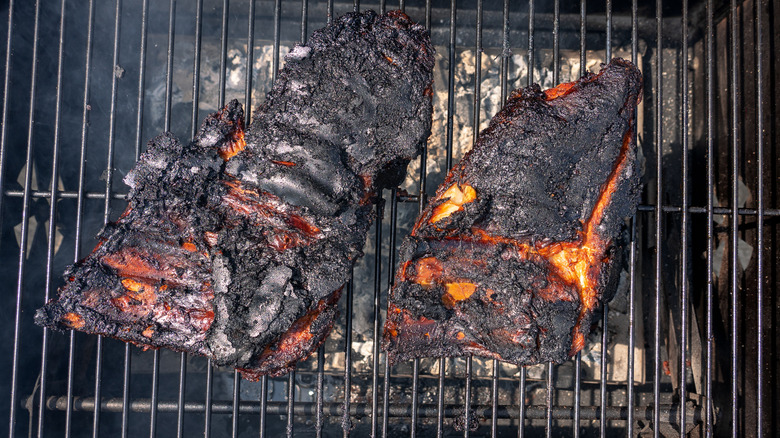 A selection overcooked meat still on the grill