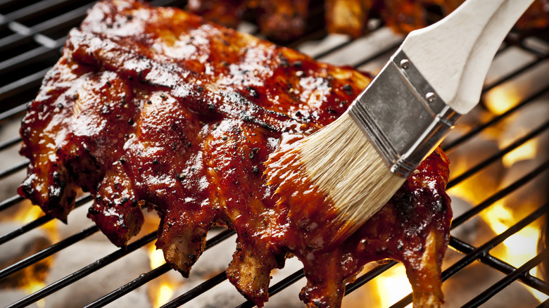 Brushing bbq sauce on ribs