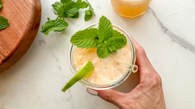 hand holding drink with straw