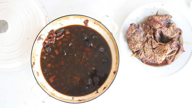 chuck roast next to pot of broth