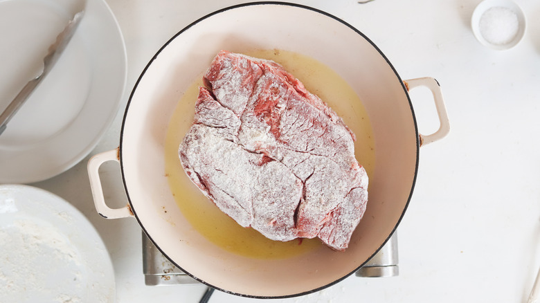 chuck roast searing in a pan