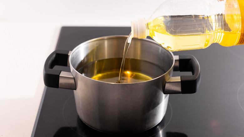 pouring frying oil into saucepan