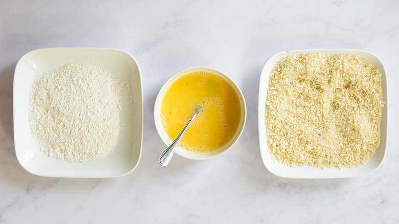 three bowls with breading ingredients