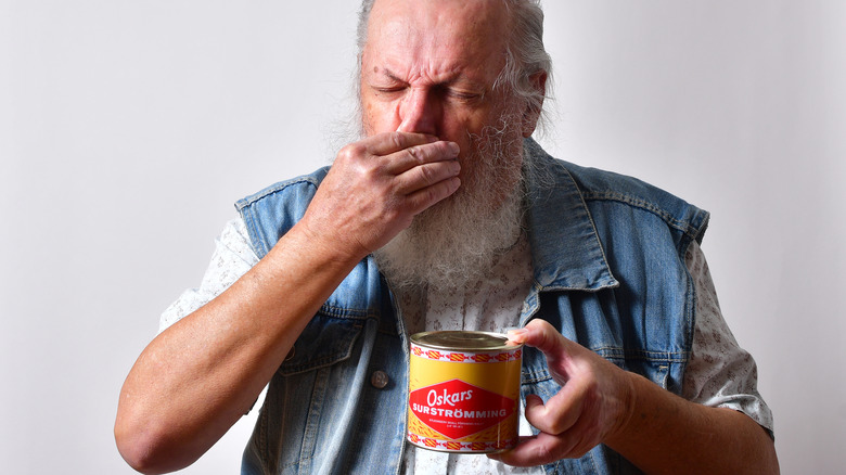 a man smelling surströmming