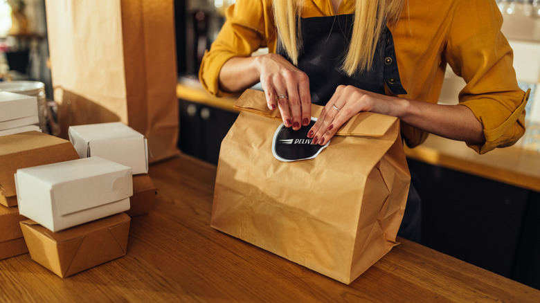 Employee packing a food delivery order