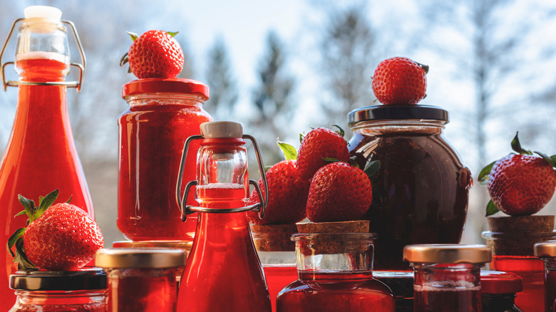 Bottles and jars of strawberry syrups and preserves