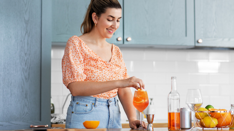 woman making cocktail at home