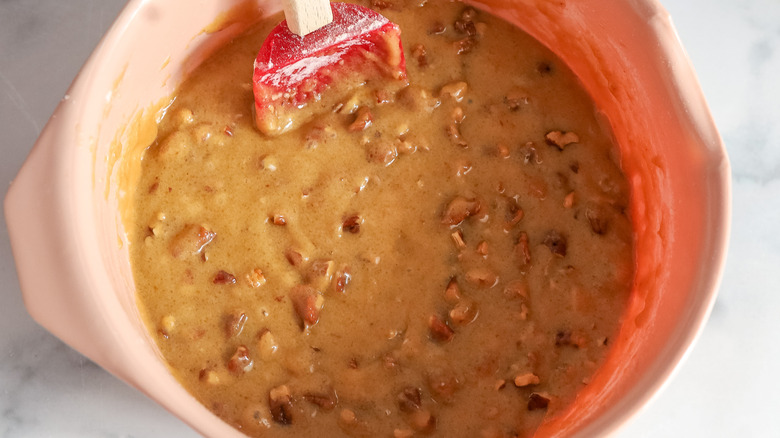 light brown batter with chopped nuts in pinkish bowl