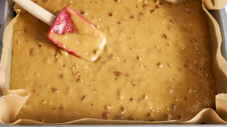 light brown batter with rubber spatula in baking pan