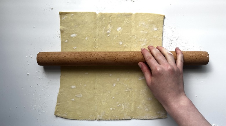 Hand rolling puff pastry with rolling pin