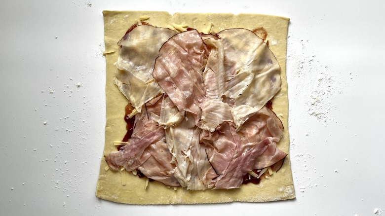 sliced ham and turkey on puff pastry sheet