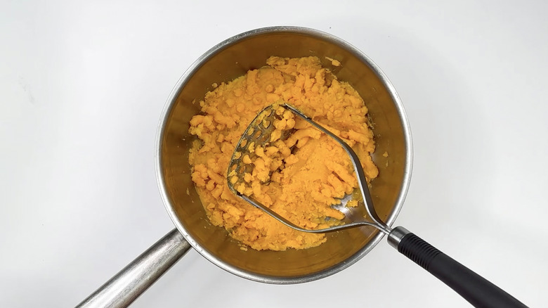 Mashing sweet potato in bowl