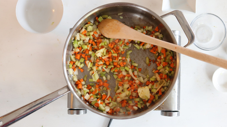 softened vegetables in pan with wooden spoon