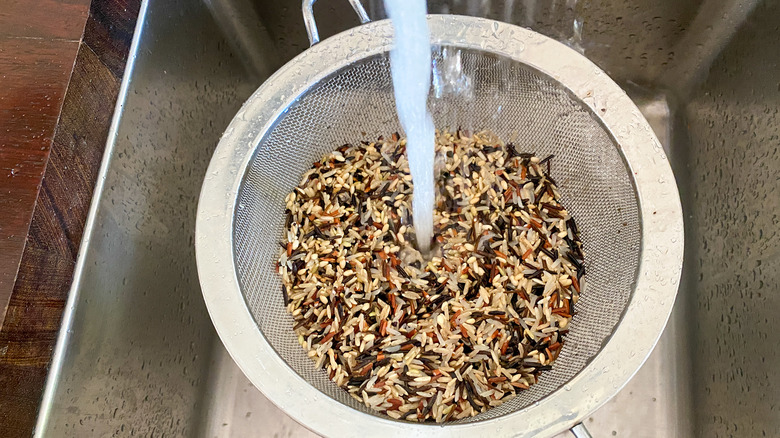 rice in colander under water