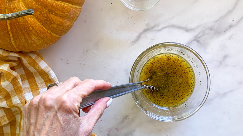 Hand mixing dressing in glass bowl