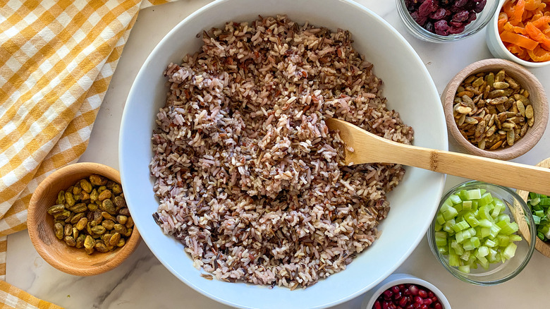 rice in white bowl surrounded by bowls of ingredients