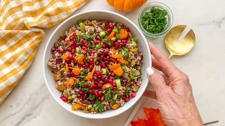 Hand holding bowl of wild rice