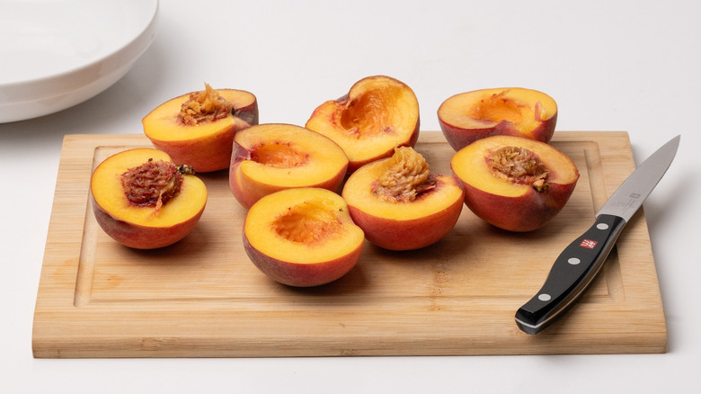 halved peaches on chopping board