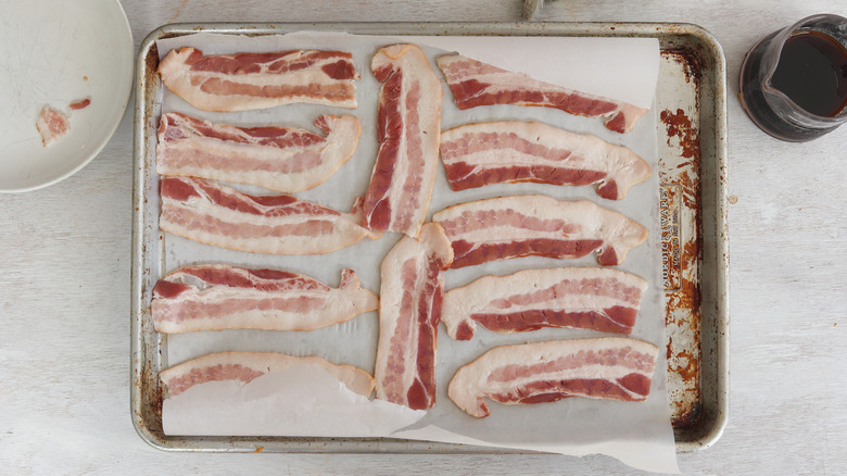 raw bacon on a baking sheet