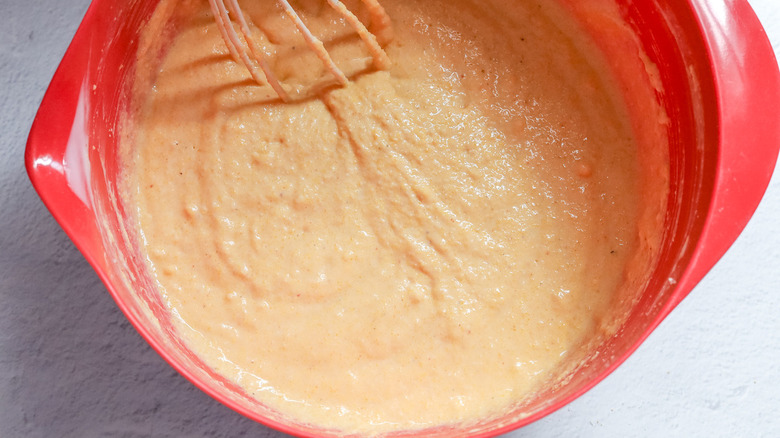 cornbread batter in red plastic bowl